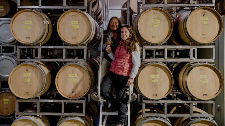 Mireia Taribó and Tara Gomez surrounded by wine barrels 