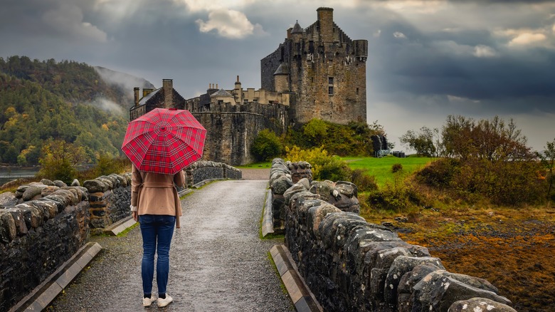 Woman looking at a castle with an umbrella 