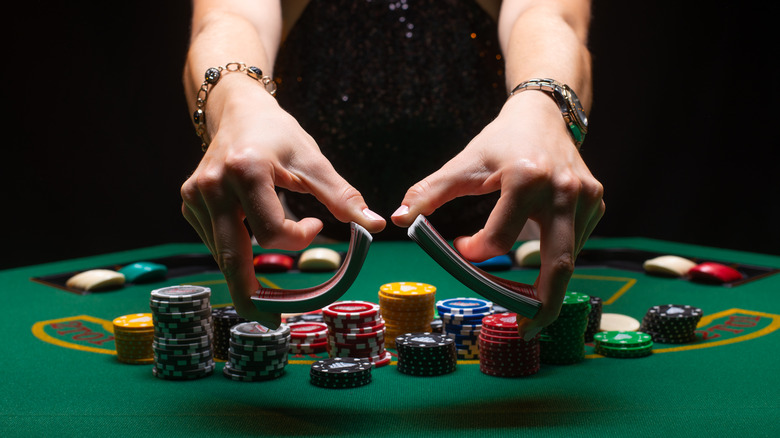 hands shuffling cards on felt