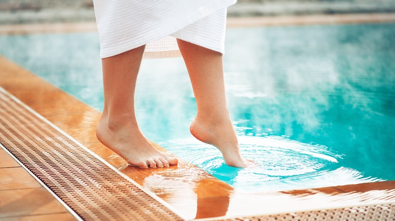 Feet stepping into hot spring 