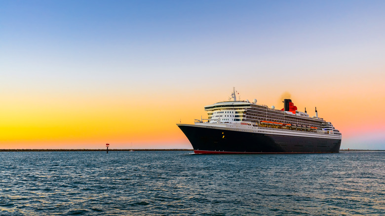 Cunard ship sails at sunset.