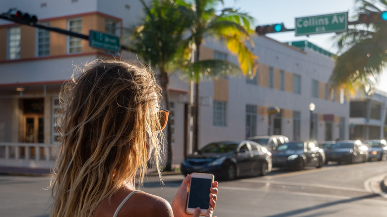 Woman using phone on road