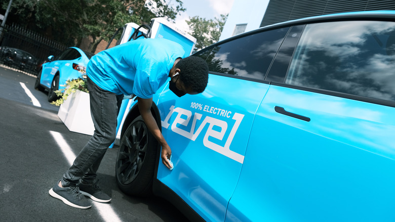 man cleans a Revel car