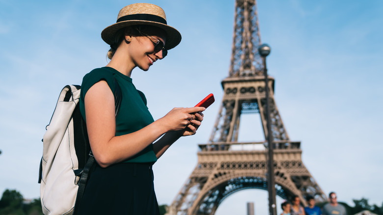 Woman holds phone in Paris