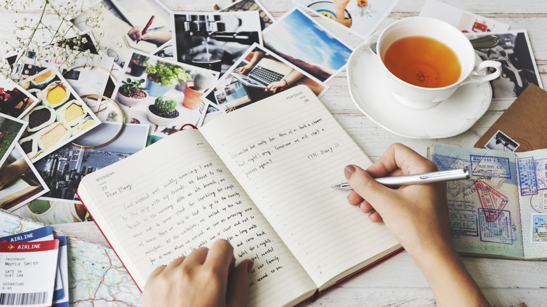 Hands writing in a journal