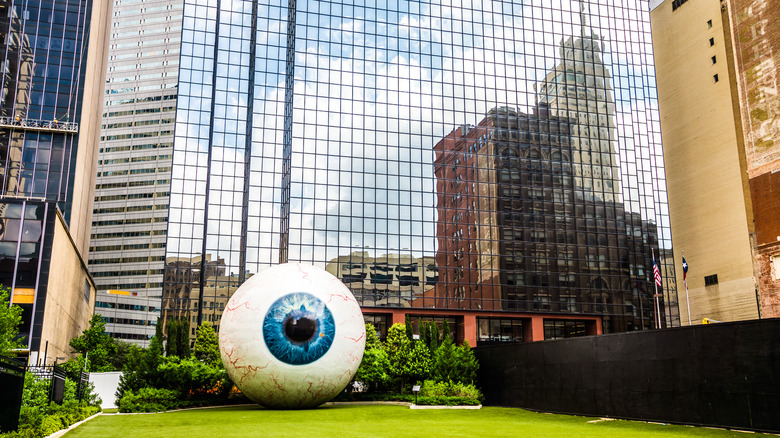 Eyeball sculpture near glass hotel