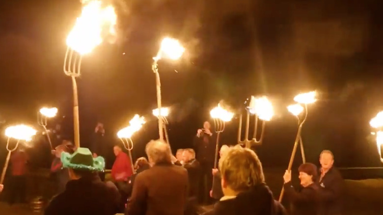 parade goers walking with torches