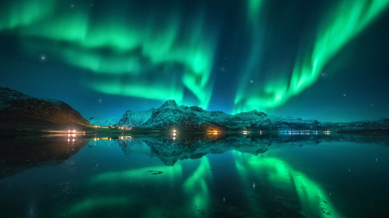 Northern Lights over water and mountains in Norway