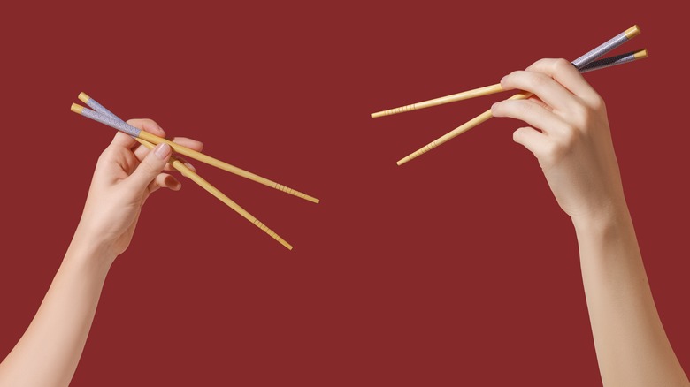 hands holding chopsticks