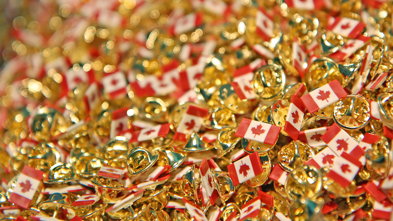 A large pile of pins notably featuring the Canadian flag
