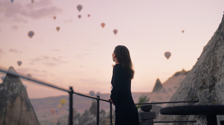 Woman looking at hot air balloons