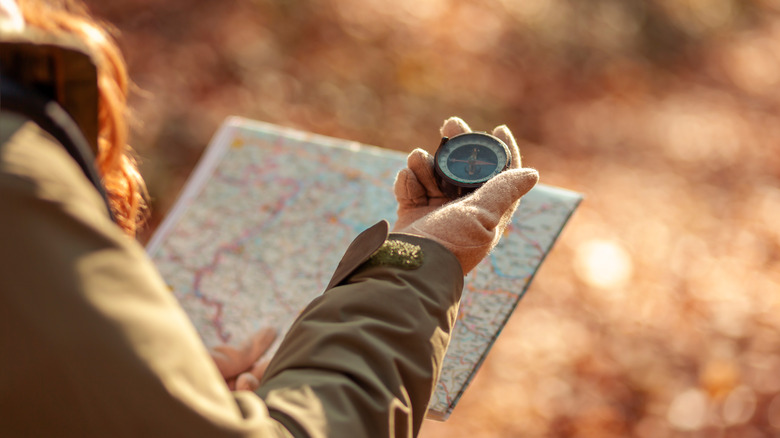 Person holding compass and map
