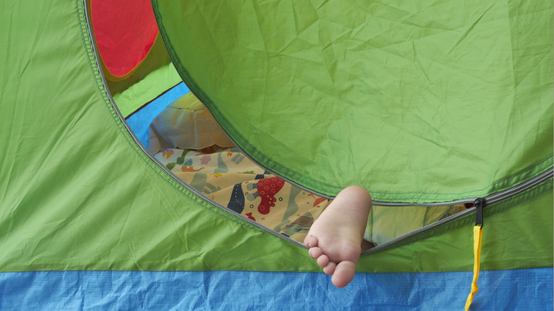 A foot through a tent door