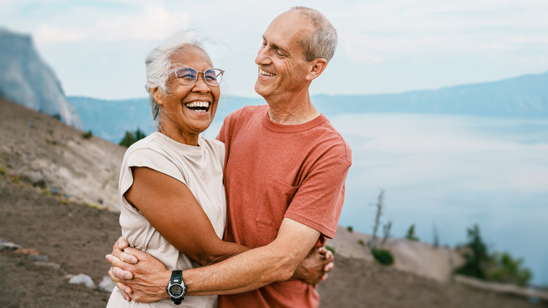 Smiling couple hugging by ocean