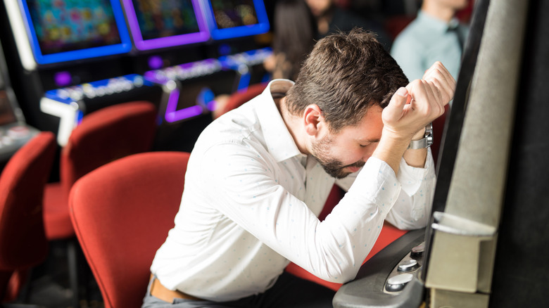 sad man at slot machine