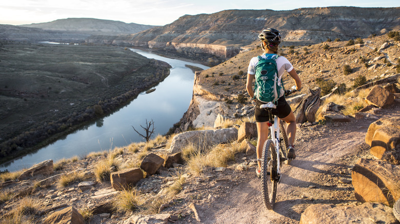 Woman mountain biking on single track trail