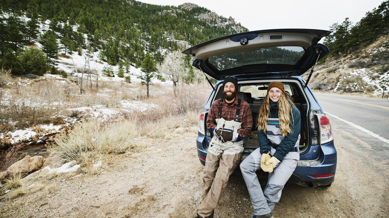 Two people sitting in back of car smiling