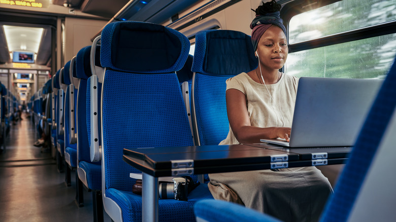 Woman on train using a laptop
