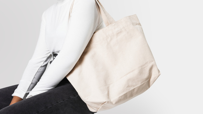 person with white tote bag