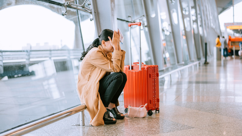 Woman crying next to luggage