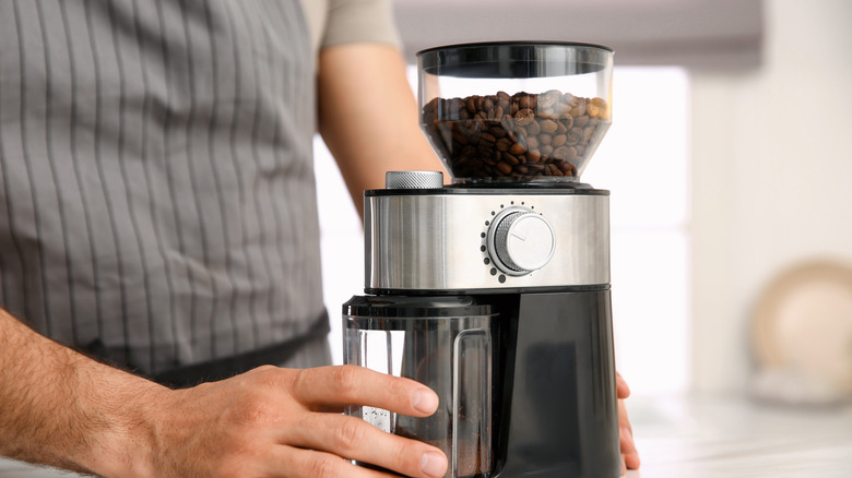 Person using coffee grinder