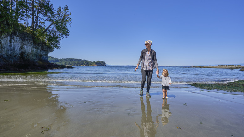 Grandmother and child walking on beach