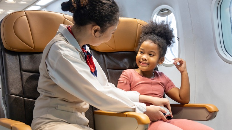 flight attendant helping young passenger