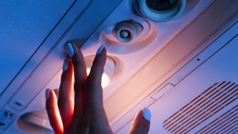 hand pressing flight attendant button