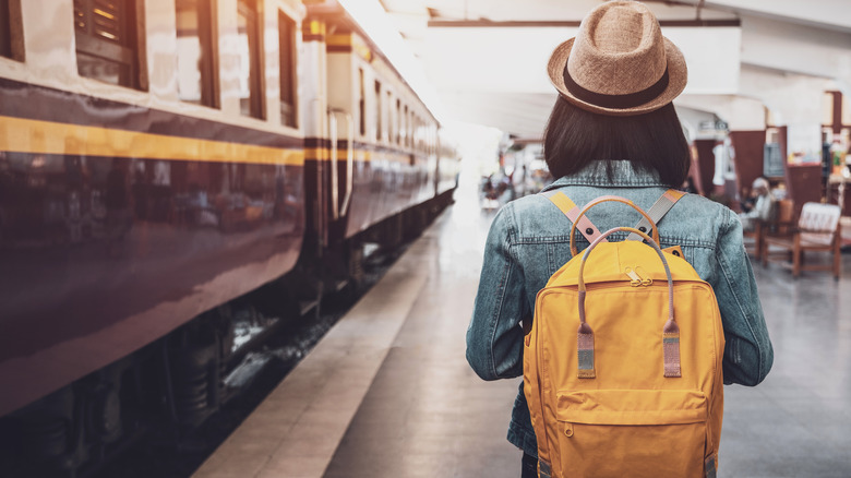 woman catching train with backpack