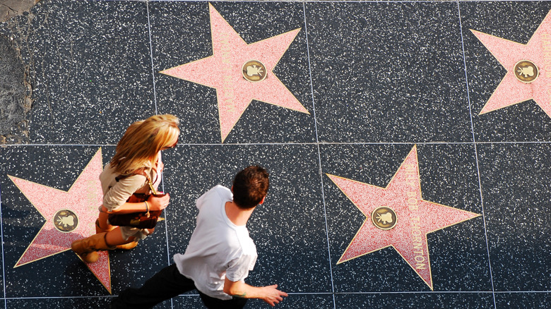 Couple walk across the Hollywood Walk of Fame