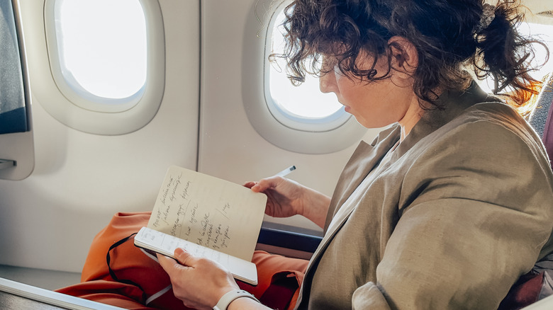 Girl journaling on plane