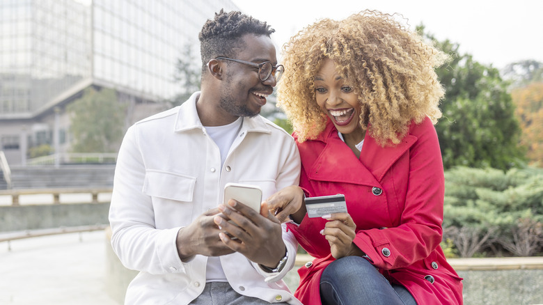 couple looking at credit card and phone