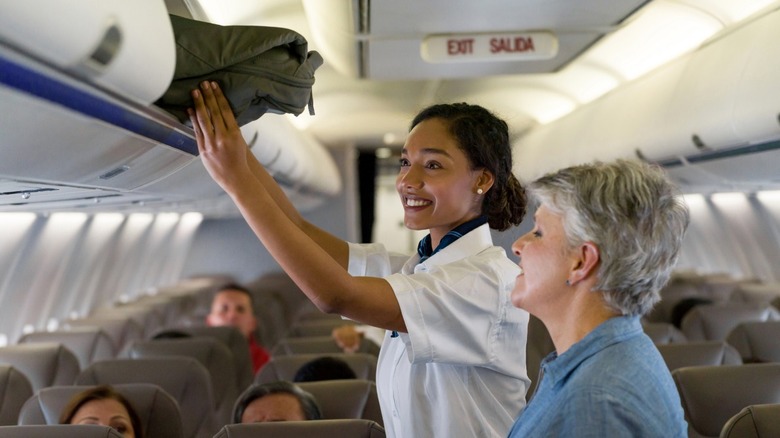 flight attendant helping passenger