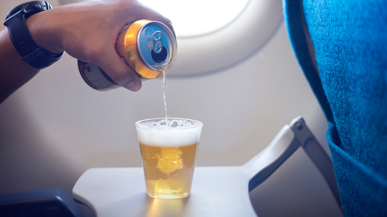 man drinking on airplane