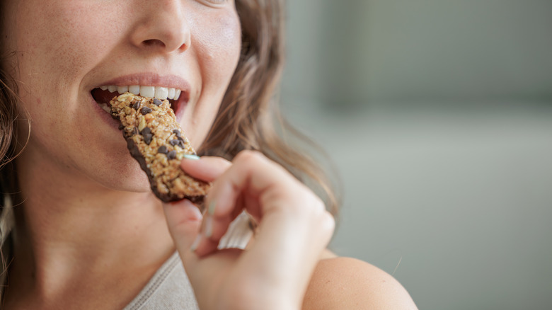 Woman eating chocolate chip granola bar