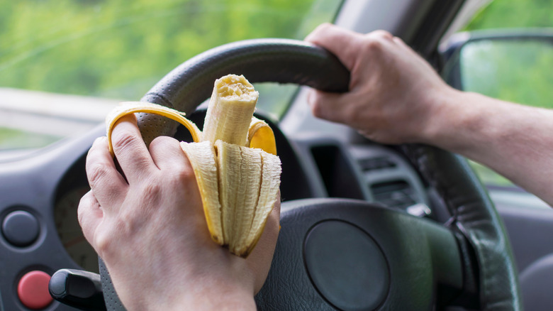 Hand on steering wheel with open banana