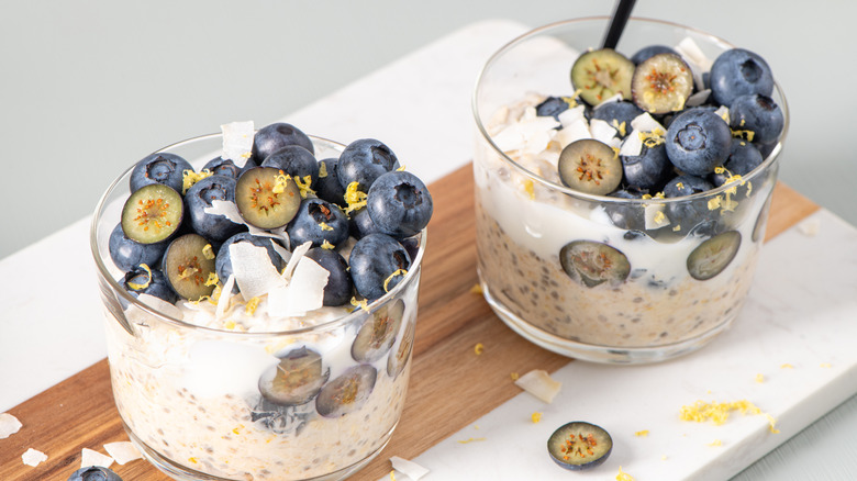 Two overnight oats jars with lemon zest and blueberries