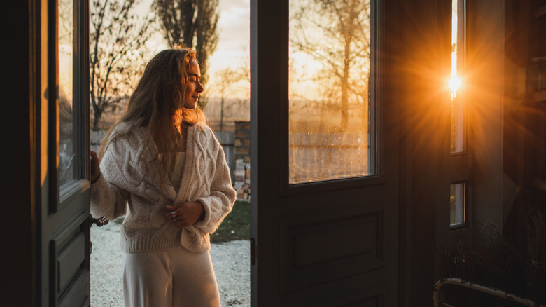 Woman in doorway at sunrise