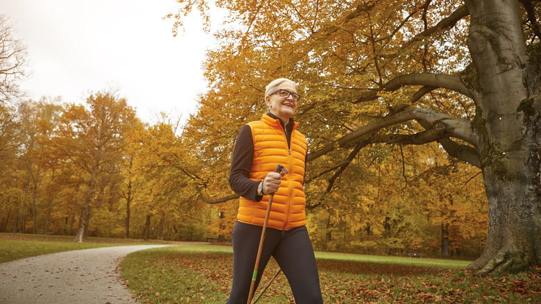 Autumn hiker wears orange vest