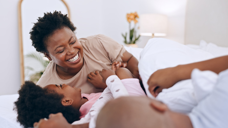 Family giggling on bed