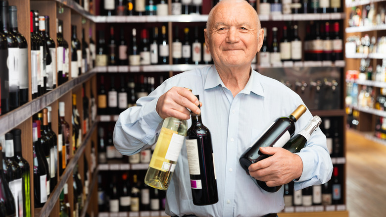 Elderly man buying wine
