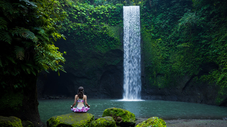 woman lotus pose by waterfall