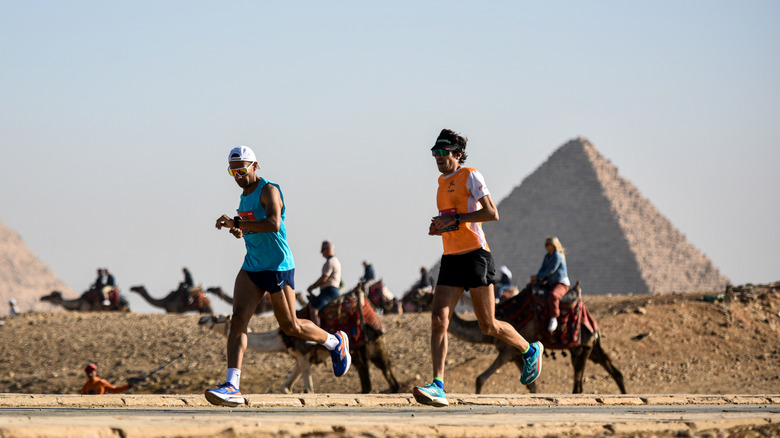 Two participants running a marathon at the pyramids