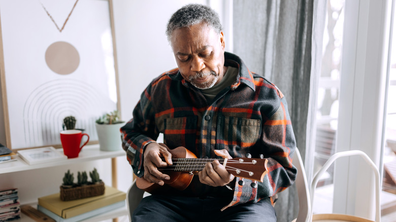 man plays ukulele