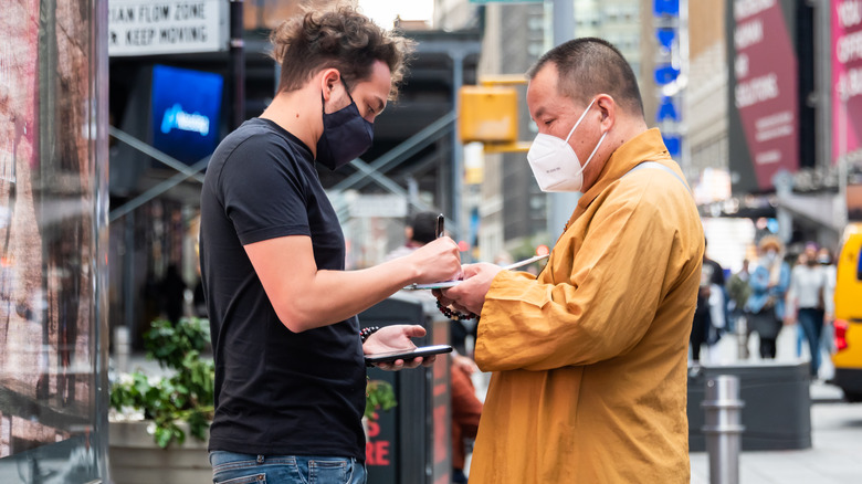 Two masked men signing something