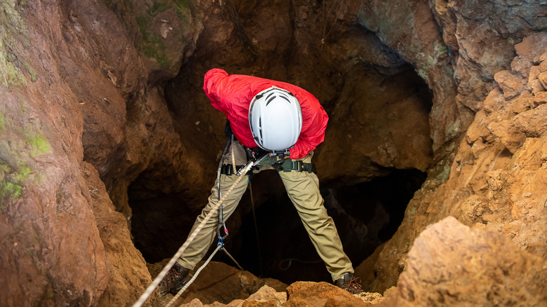 climber descending into cave