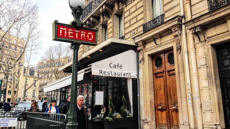 An outdoor scene depicting a resturuant and a metro station sign