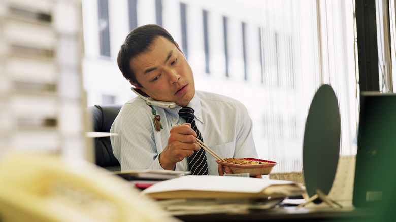 businessman eats while on the phone