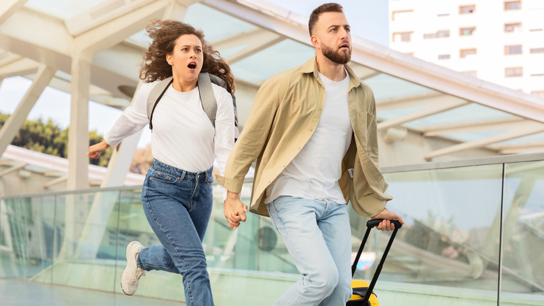 A couple rushing at the airport