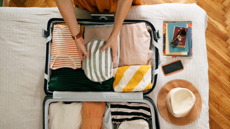 a woman organizing her suitcase for a cruise